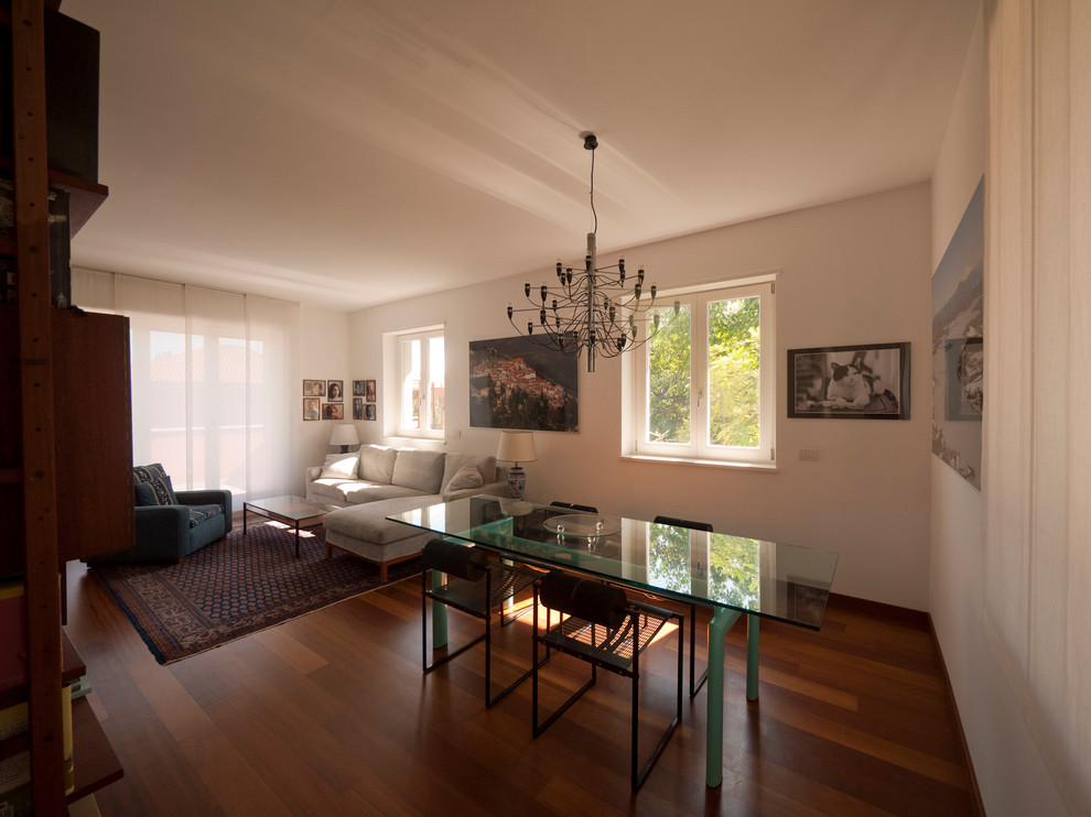 Foto de sala de estar con biblioteca abierta ecléctica de tamaño medio sin chimenea con paredes blancas, suelo de madera en tonos medios y televisor independiente