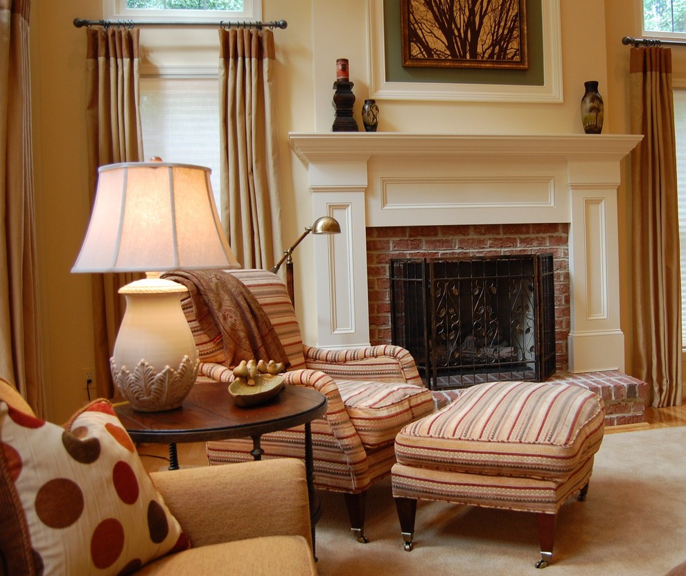 Inspiration pour une salle de séjour traditionnelle avec un mur beige, une cheminée standard et un manteau de cheminée en brique.