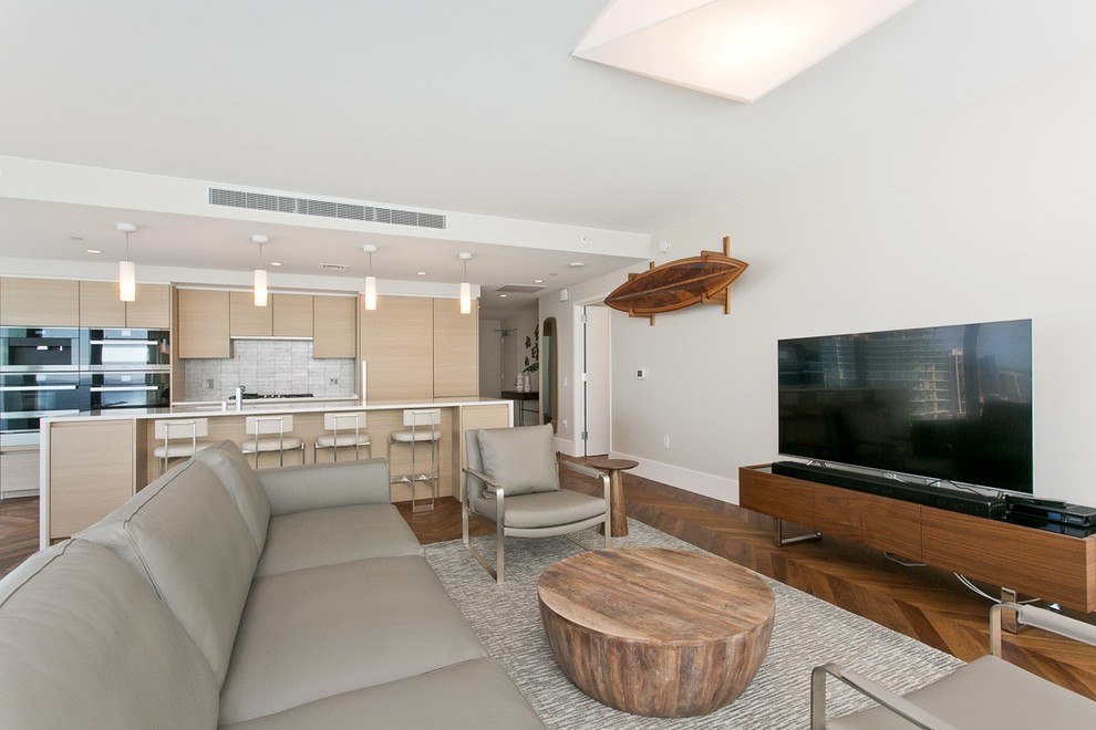 Offenes Maritimes Wohnzimmer mit weißer Wandfarbe, dunklem Holzboden, freistehendem TV und braunem Boden in Hawaii