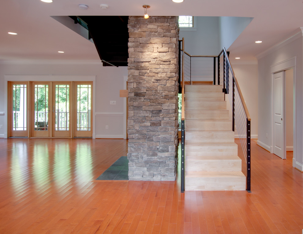 Cette photo montre une salle de séjour tendance ouverte avec un sol en bois brun, une cheminée standard et un manteau de cheminée en pierre.