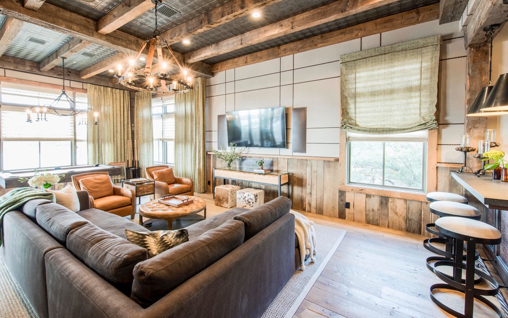 Ejemplo de sala de juegos en casa abierta de estilo de casa de campo grande con suelo de madera clara y televisor colgado en la pared