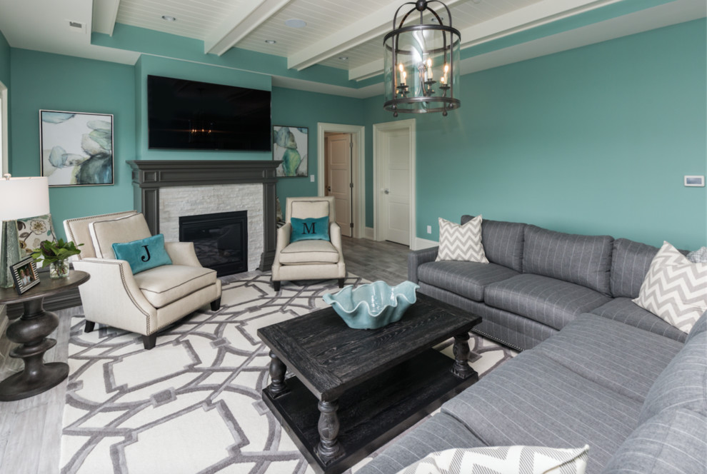 Großes, Offenes Modernes Wohnzimmer mit blauer Wandfarbe, gebeiztem Holzboden, Kamin, Kaminumrandung aus Stein und TV-Wand in Sonstige