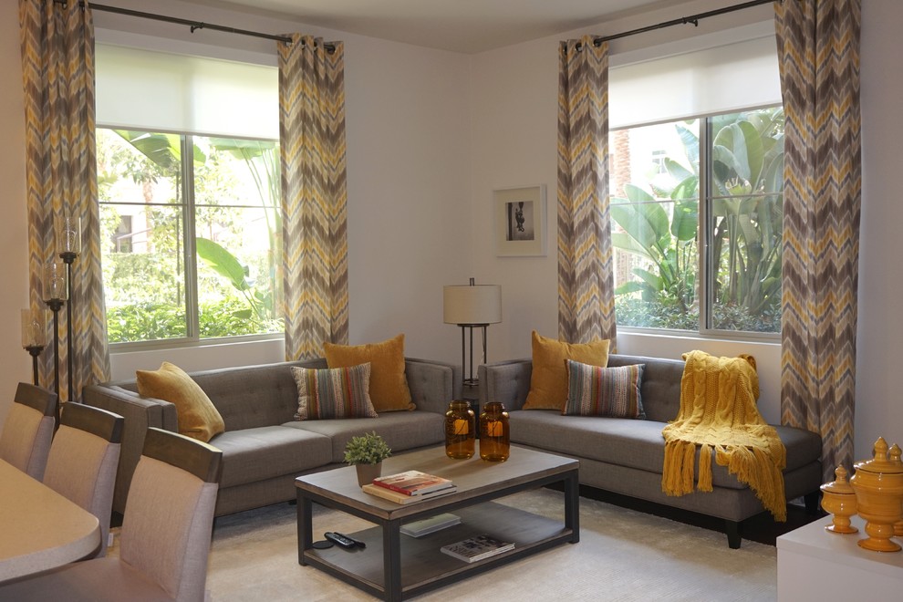 Modelo de sala de estar abierta contemporánea con paredes grises, televisor colgado en la pared y moqueta