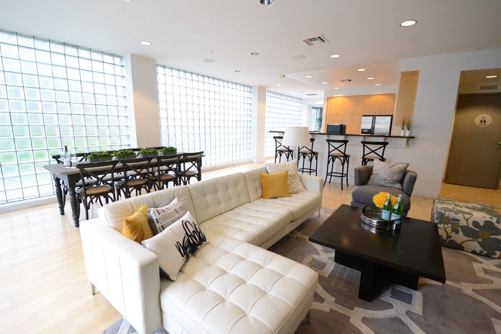 Ejemplo de sala de estar con barra de bar abierta urbana de tamaño medio con paredes blancas y suelo de madera clara