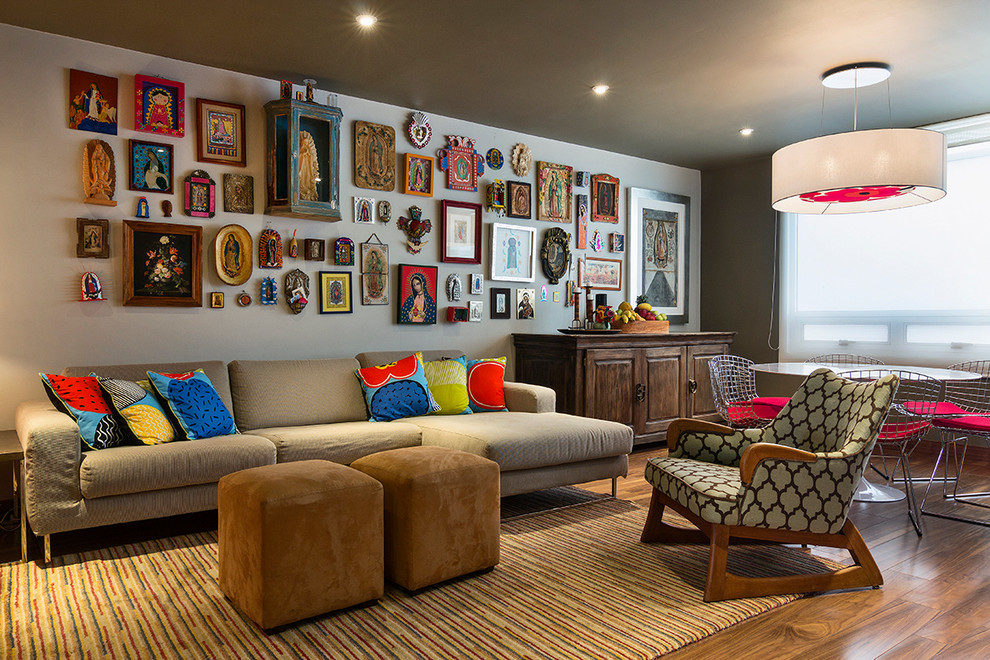 Diseño de sala de estar bohemia con suelo de madera en tonos medios y paredes grises