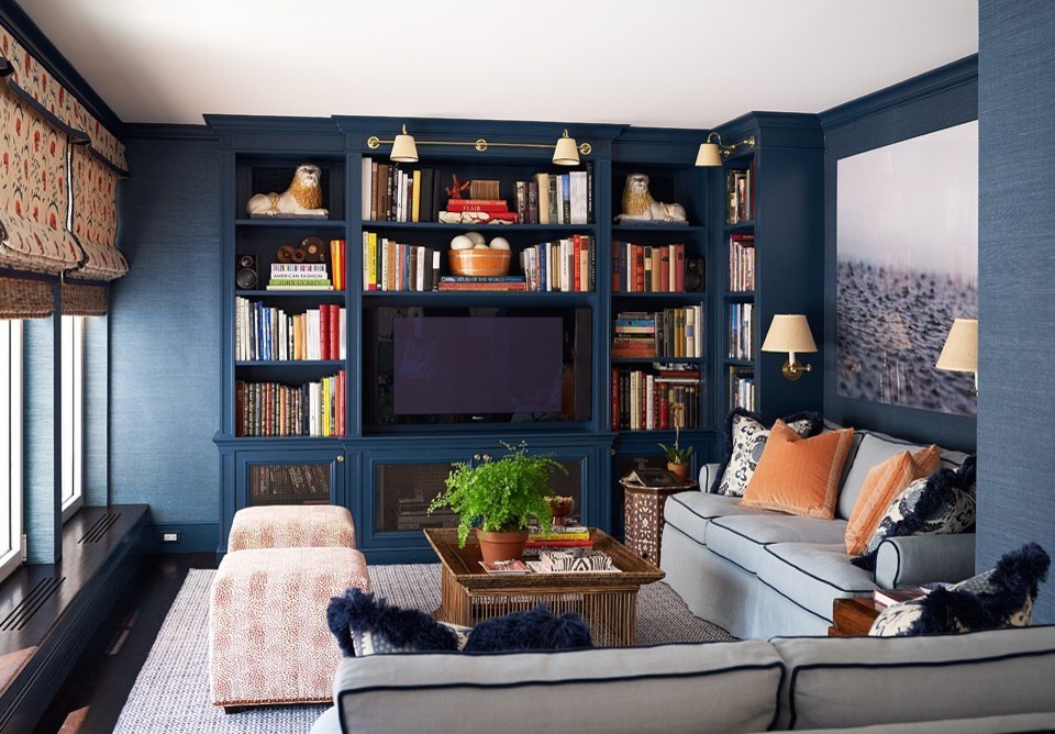 Cette image montre une salle de séjour traditionnelle fermée avec une bibliothèque ou un coin lecture, un mur bleu, parquet foncé et un téléviseur encastré.