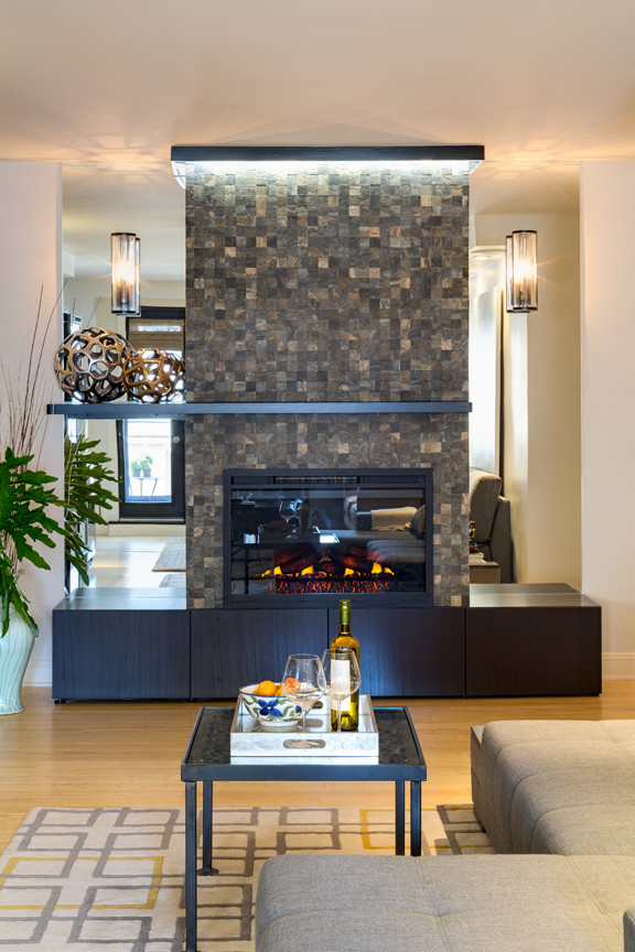 Medium sized modern open plan games room in New York with light hardwood flooring and a standard fireplace.