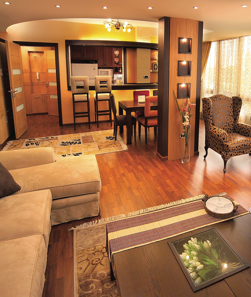 Exemple d'une salle de séjour tendance de taille moyenne et ouverte avec un mur beige, parquet foncé, un téléviseur fixé au mur et un sol marron.