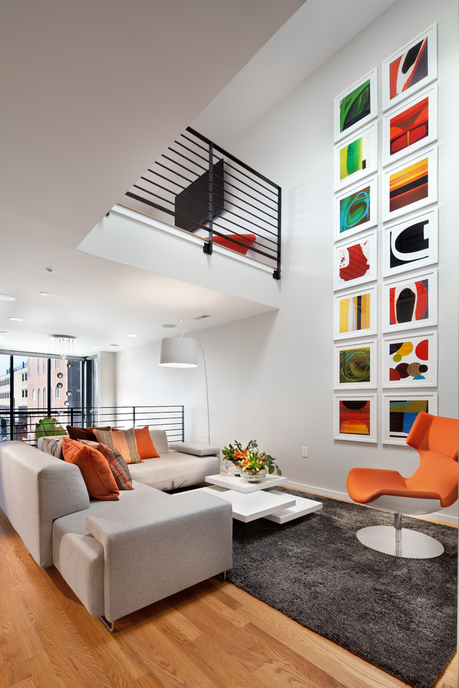 Diseño de sala de estar abierta contemporánea con paredes blancas, suelo de madera en tonos medios y suelo marrón