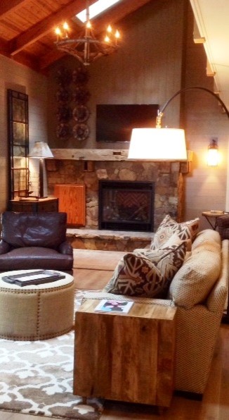 Imagen de sala de estar tipo loft rústica de tamaño medio con suelo de madera en tonos medios, todas las chimeneas y marco de chimenea de piedra