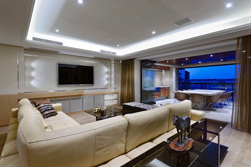 Ejemplo de salón abierto actual con paredes beige y televisor colgado en la pared
