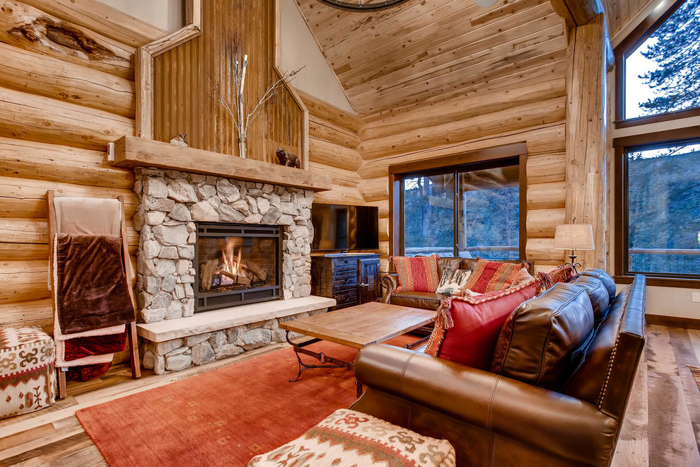 Family room - mid-sized rustic open concept medium tone wood floor family room idea in Denver with a standard fireplace, a stone fireplace and a tv stand
