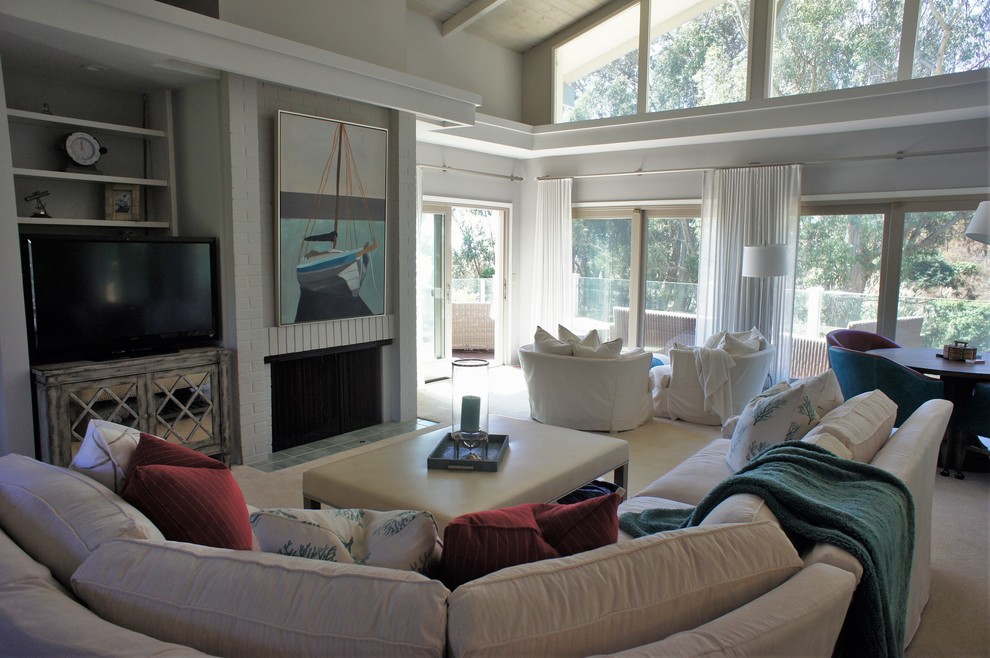 Пример оригинального дизайна: гостиная комната среднего размера в морском стиле с серыми стенами, ковровым покрытием, стандартным камином, фасадом камина из кирпича, отдельно стоящим телевизором и бежевым полом