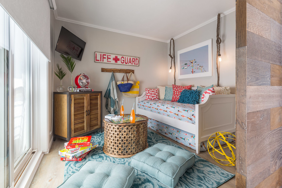 Immagine di un soggiorno stile marinaro con pareti grigie, parquet chiaro, TV a parete e pavimento beige