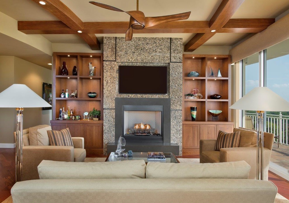Transitional medium tone wood floor family room photo in Miami with a standard fireplace and a wall-mounted tv