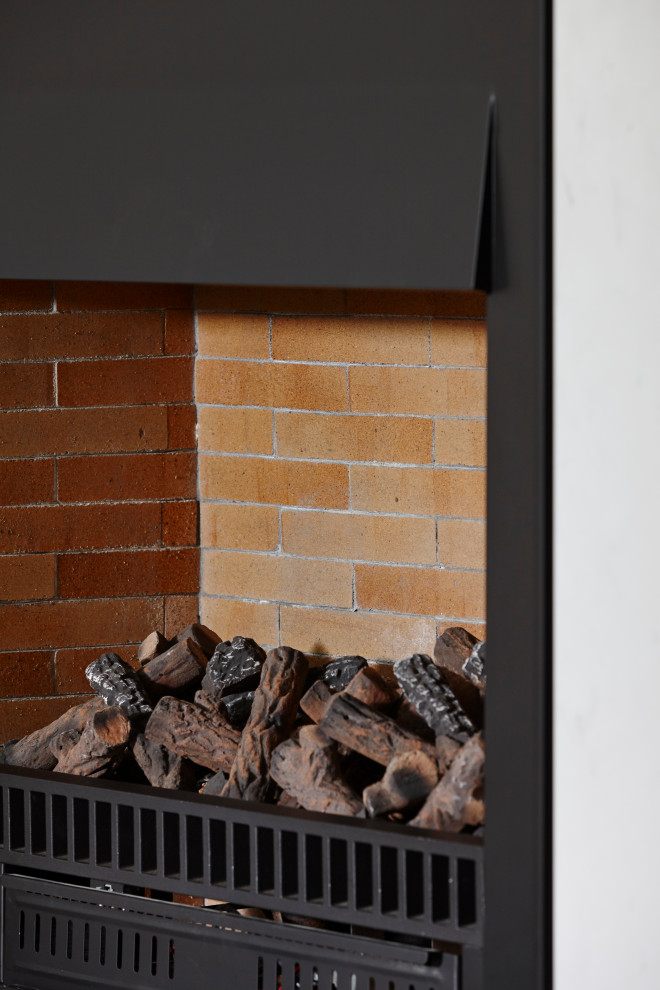 オークランドにある中くらいなトラディショナルスタイルのおしゃれなオープンリビング (白い壁、淡色無垢フローリング、薪ストーブ、レンガの暖炉まわり、茶色い床、格子天井) の写真