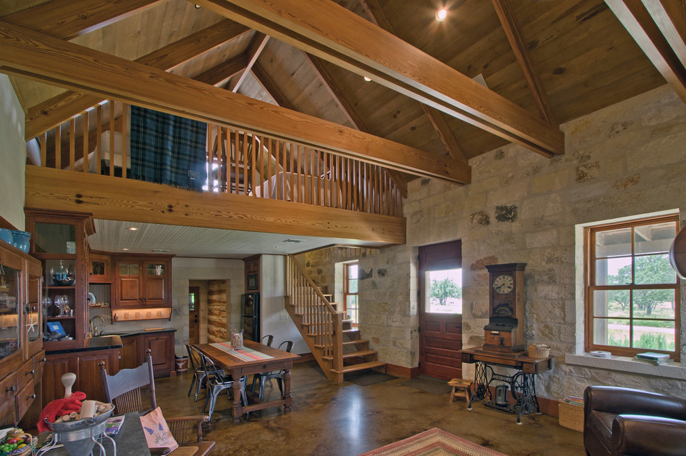 Diseño de sala de estar abierta de estilo de casa de campo grande sin chimenea con paredes beige, suelo de cemento y suelo marrón