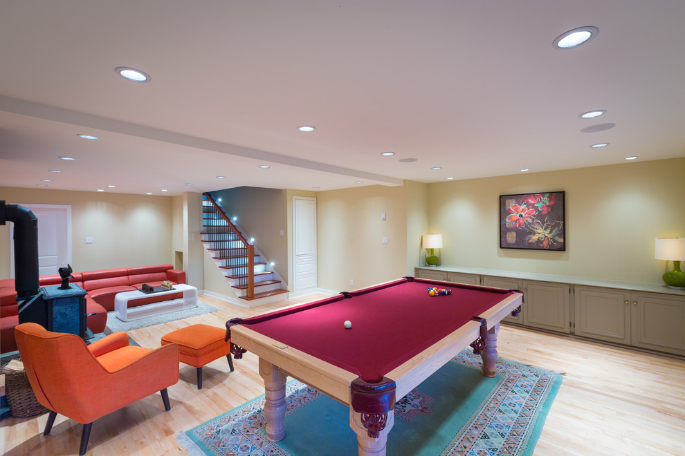 Large contemporary open plan games room in Vancouver with yellow walls, light hardwood flooring, a standard fireplace, a stone fireplace surround and no tv.