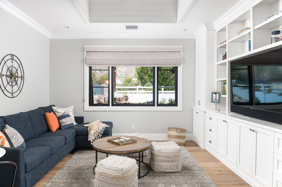 Idee per un soggiorno tradizionale chiuso con pareti grigie, parquet chiaro, parete attrezzata, pavimento beige e tappeto