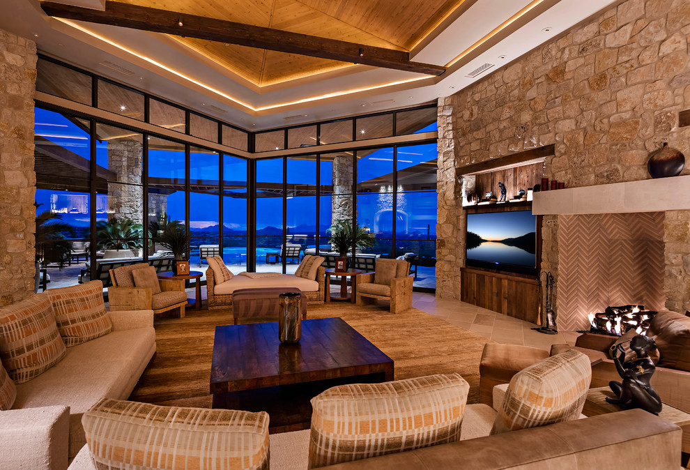 Design ideas for an enclosed games room in Phoenix with a standard fireplace, a stone fireplace surround, a wall mounted tv and beige floors.