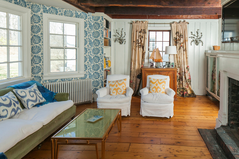 Mittelgroßes, Abgetrenntes Landhaus Wohnzimmer mit weißer Wandfarbe, braunem Holzboden, Kamin, TV-Wand, Kaminumrandung aus Holz und orangem Boden in New York