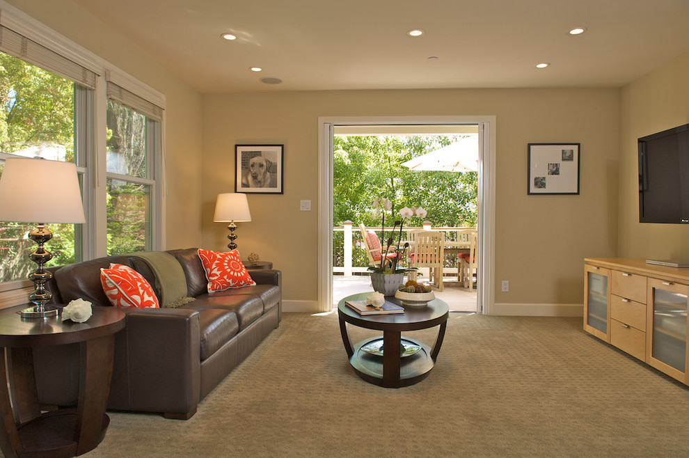 Diseño de sala de estar actual con paredes beige, moqueta y televisor colgado en la pared