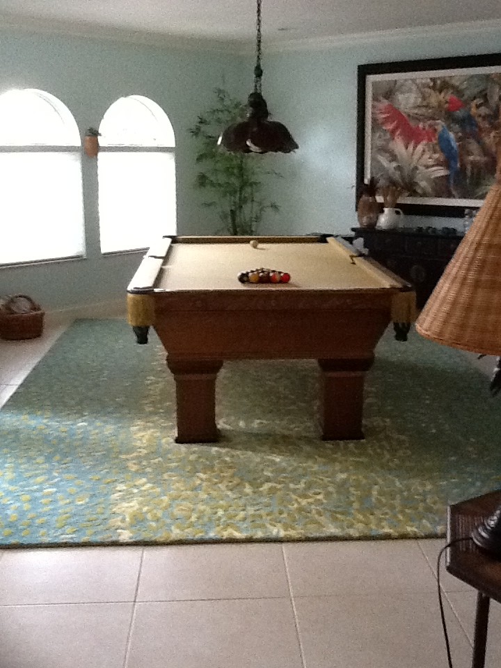 Cette image montre une salle de séjour design avec salle de jeu, un mur bleu et un sol en carrelage de porcelaine.