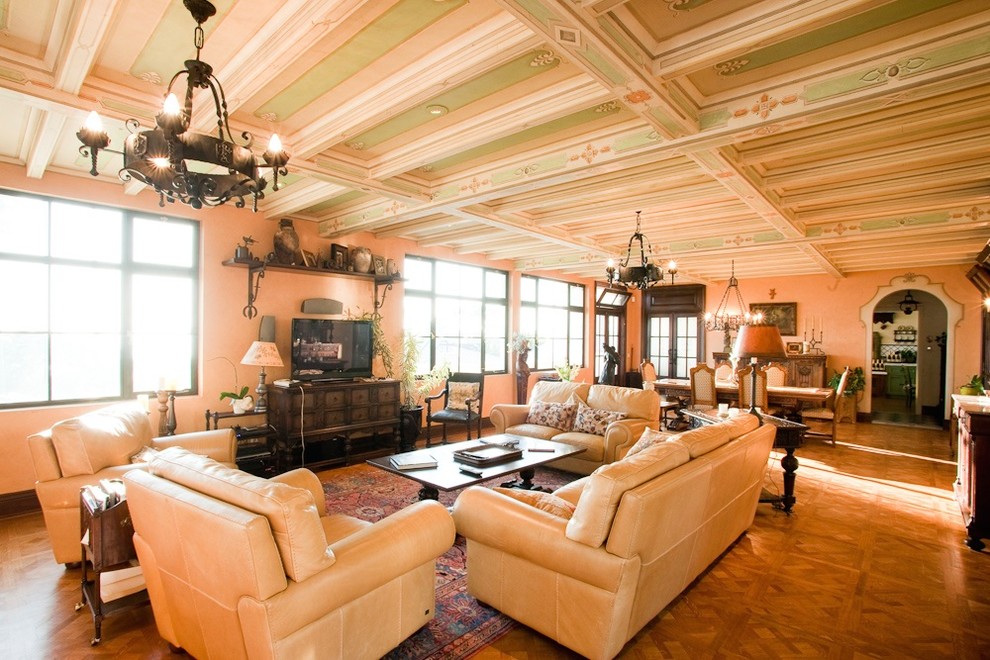 Offenes Klassisches Wohnzimmer mit oranger Wandfarbe, braunem Holzboden und freistehendem TV in San Diego