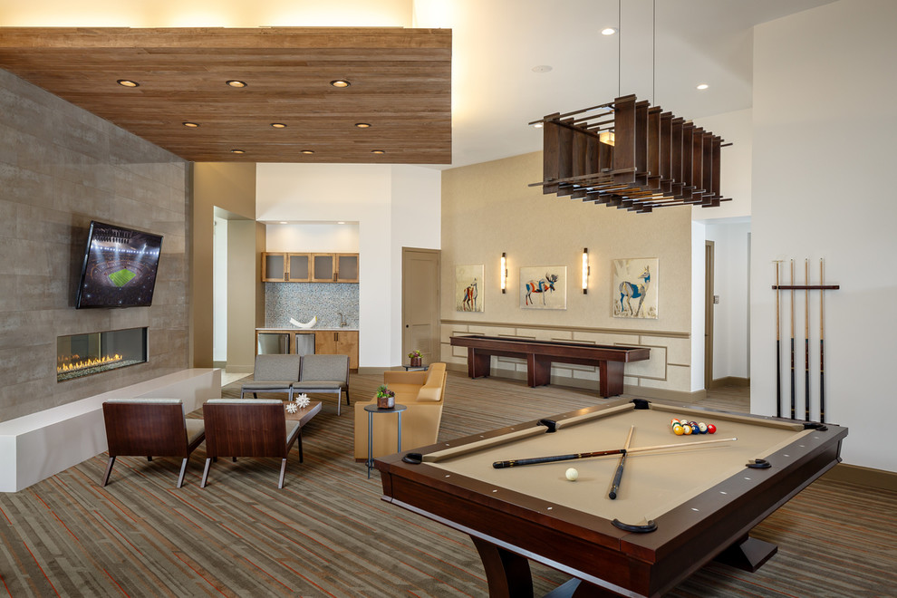 Offenes Modernes Wohnzimmer mit beiger Wandfarbe, dunklem Holzboden, Tunnelkamin, Kaminumrandung aus Stein und TV-Wand in Austin