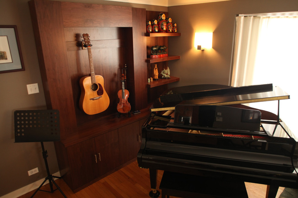 Imagen de sala de estar con rincón musical actual de tamaño medio sin chimenea y televisor con paredes grises y suelo de madera en tonos medios