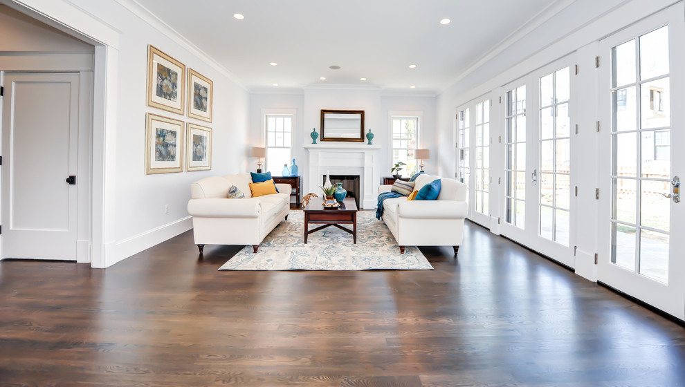 Example of a mid-sized classic enclosed dark wood floor family room design in DC Metro with white walls, a standard fireplace and a wood fireplace surround