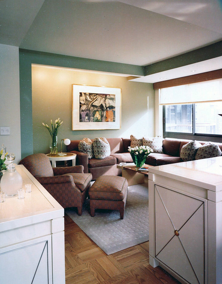Klassisk inredning av ett mellanstort allrum med öppen planlösning, med gröna väggar, ljust trägolv och en dold TV