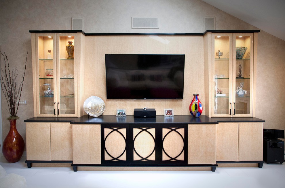 Modelo de sala de estar abierta actual de tamaño medio sin chimenea con paredes beige, suelo de baldosas de cerámica y pared multimedia