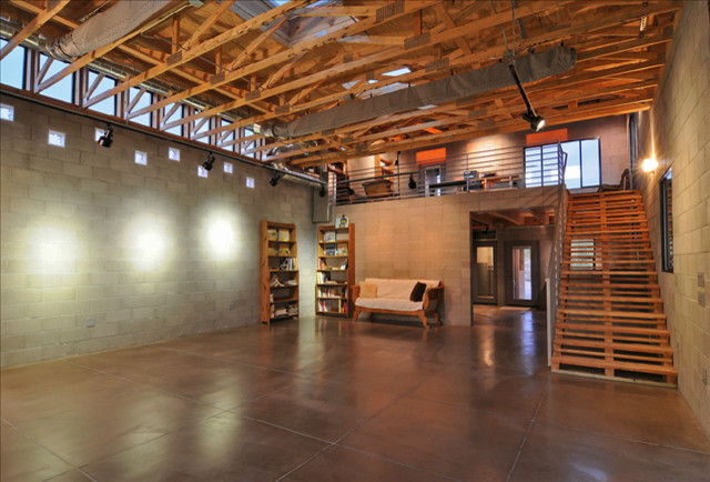 フェニックスにある高級な広いインダストリアルスタイルのおしゃれなロフトリビング (ライブラリー、グレーの壁、コンクリートの床) の写真