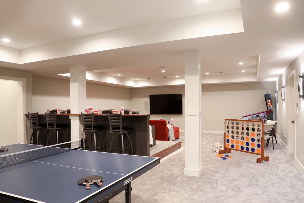 Photo of a large contemporary enclosed games room in Milwaukee with a game room, beige walls, carpet, a wall mounted tv and grey floors.