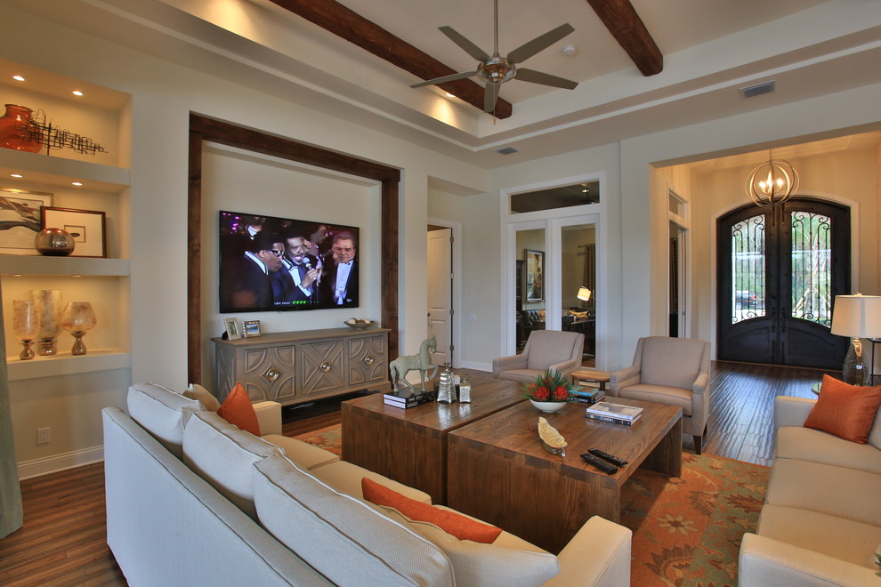 Immagine di un grande soggiorno boho chic aperto con pareti beige, pavimento in legno massello medio, nessun camino e TV a parete