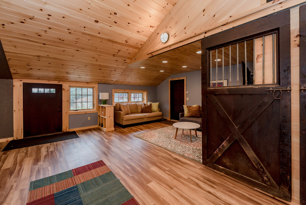 Example of a large cottage open concept light wood floor and brown floor game room design in Boston with gray walls