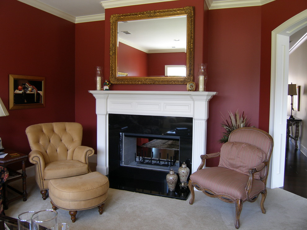 Diseño de sala de estar cerrada clásica renovada pequeña sin televisor con paredes rojas, moqueta, chimenea de doble cara, marco de chimenea de madera y suelo beige