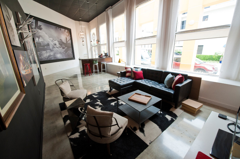 Ejemplo de sala de estar abierta actual de tamaño medio con paredes blancas, suelo de cemento y televisor independiente