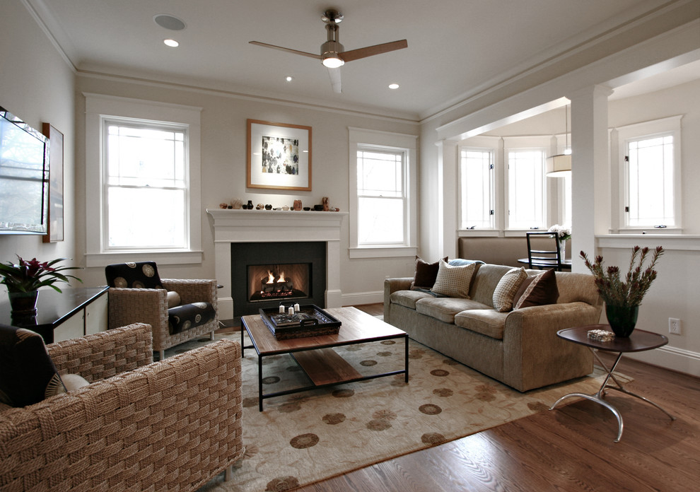 Idee per un soggiorno classico con pareti beige, pavimento in legno massello medio, camino classico, pavimento beige e tappeto