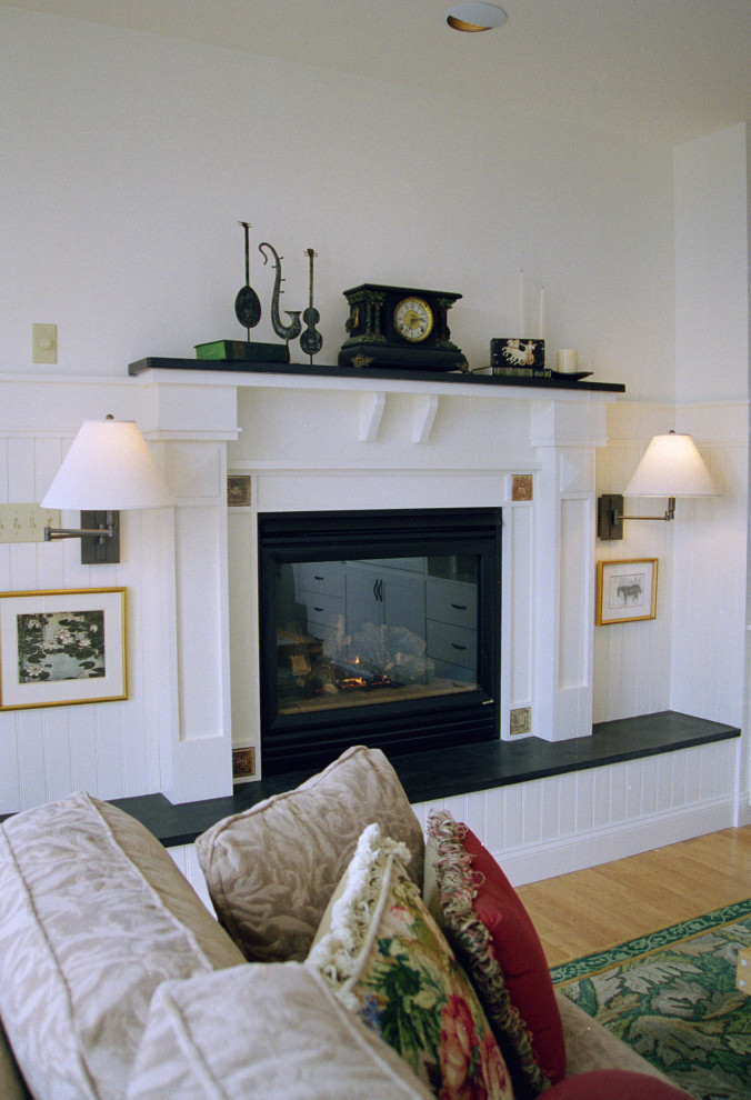 Aménagement d'une grande salle de séjour craftsman ouverte avec un mur blanc, parquet en bambou, une cheminée standard, un manteau de cheminée en pierre, un téléviseur encastré et un sol marron.