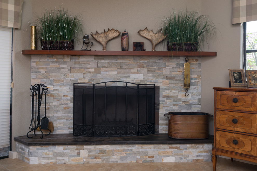 Aménagement d'une salle de séjour craftsman avec une cheminée standard et un manteau de cheminée en pierre.