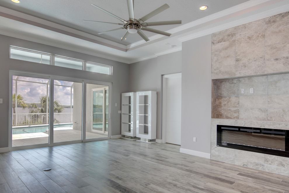 Design ideas for a large contemporary open plan games room in Tampa with grey walls, ceramic flooring, a ribbon fireplace, a built-in media unit and grey floors.
