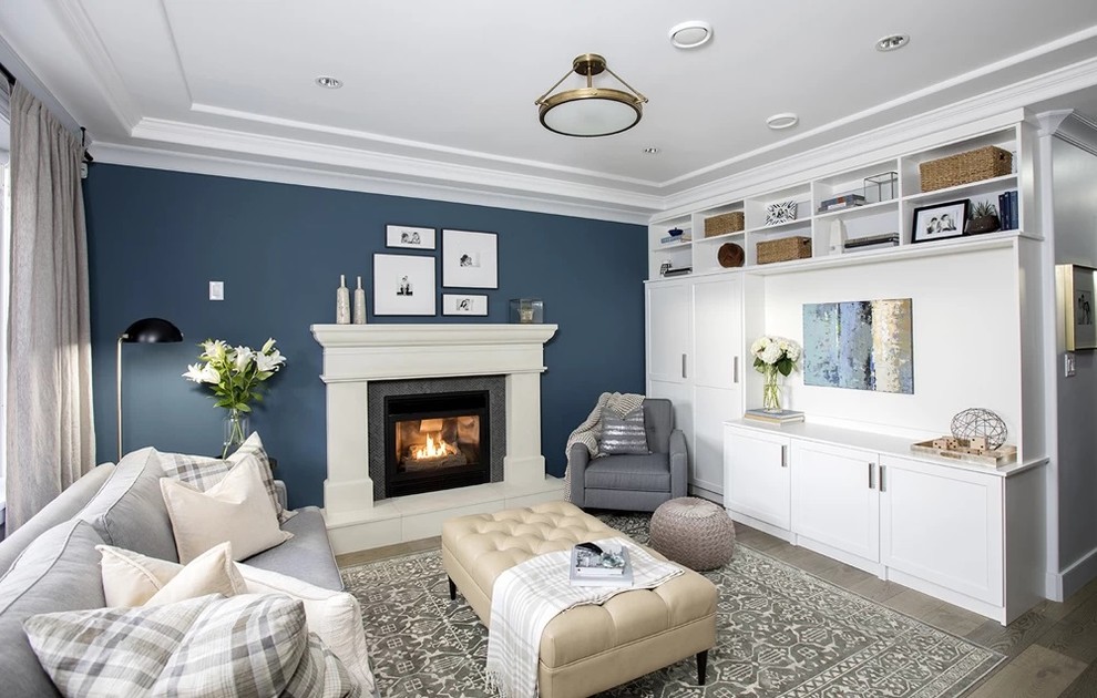 Diseño de sala de estar cerrada tradicional de tamaño medio con paredes azules, suelo de madera clara, todas las chimeneas y suelo beige