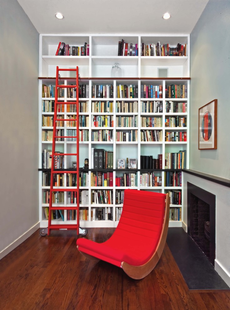 Imagen de sala de estar con biblioteca contemporánea con paredes grises y suelo de madera oscura