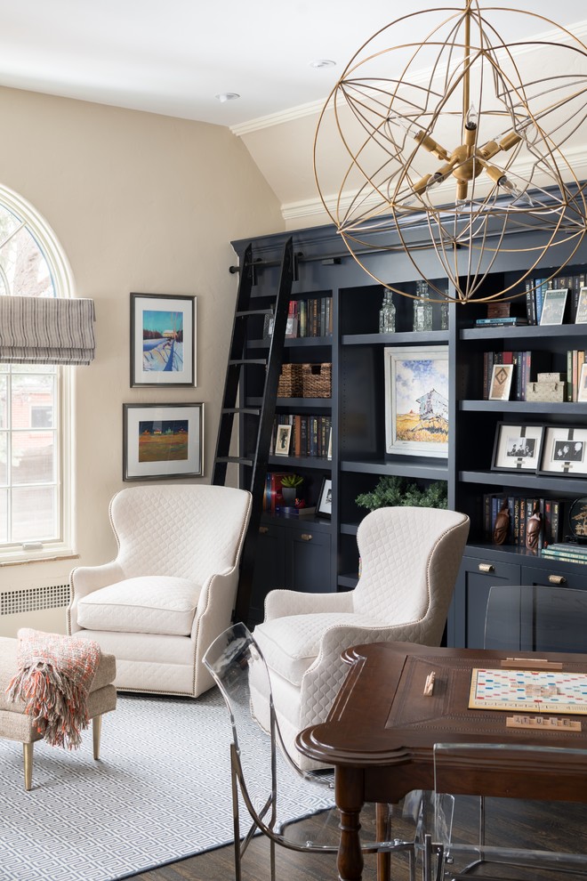 Ispirazione per un grande soggiorno classico con libreria, pareti beige, parquet scuro, nessuna TV e pavimento marrone