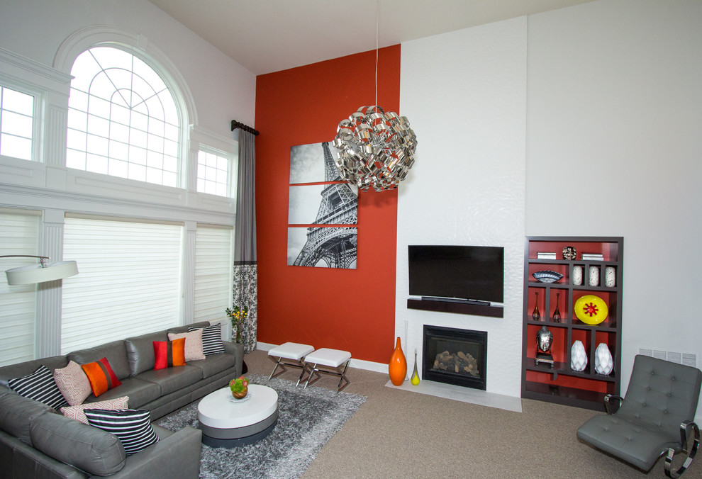 Пример оригинального дизайна: большая открытая гостиная комната в стиле модернизм с красными стенами, ковровым покрытием, стандартным камином, фасадом камина из плитки, телевизором на стене и серым полом