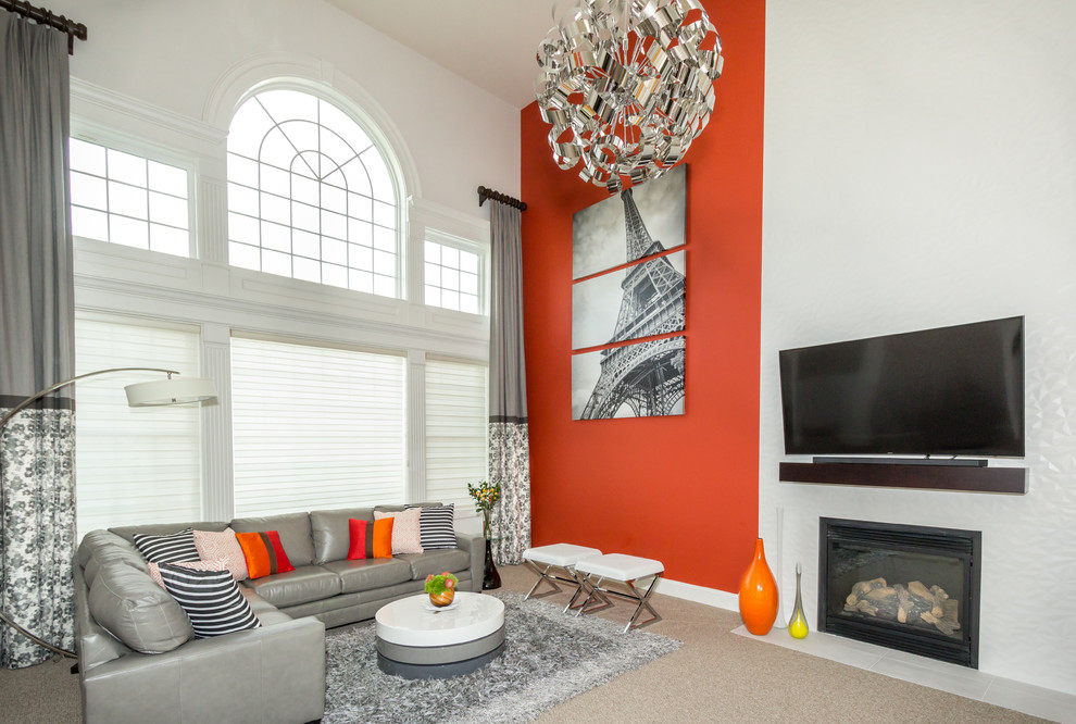 Источник вдохновения для домашнего уюта: большая открытая гостиная комната в стиле модернизм с красными стенами, ковровым покрытием, стандартным камином, фасадом камина из плитки, телевизором на стене и серым полом