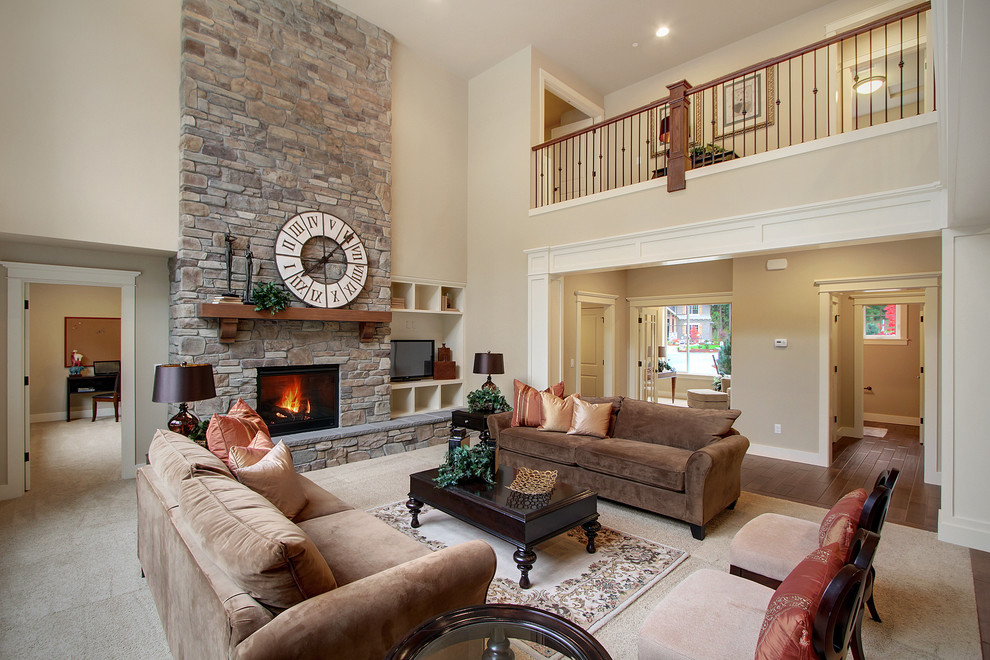 Modelo de sala de estar abierta de estilo americano con paredes beige, moqueta, todas las chimeneas y marco de chimenea de piedra