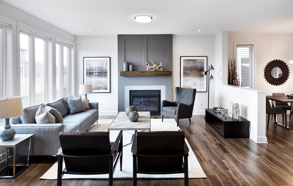 Photo of an open plan games room in Ottawa with white walls, medium hardwood flooring, a standard fireplace and a wooden fireplace surround.